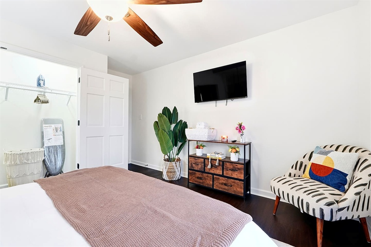 Upstairs bedroom located to the right, featuring a floral-inspired design and a comfortable double bed. Includes a smart TV and easy access to a shared bathroom. This room includes 2 full-body towels, 2 washcloths, and 2 hand towels for your stay.