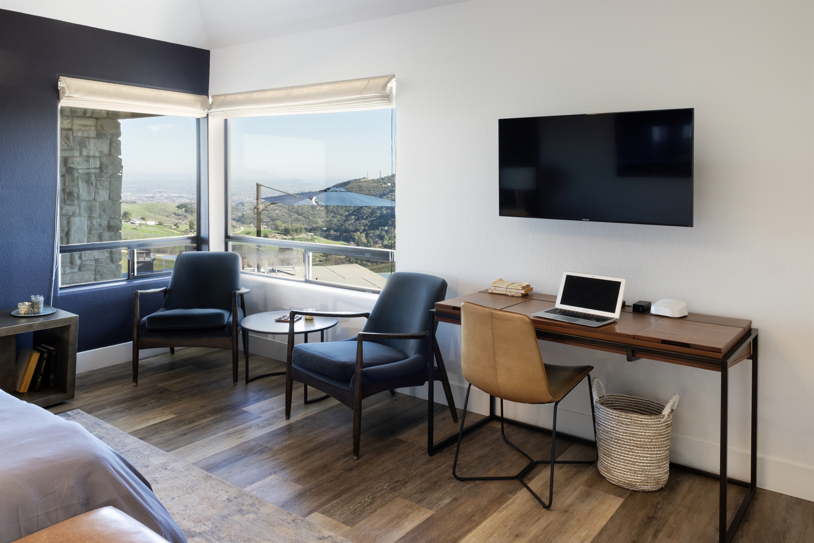The master suite offers more than just a place to sleep — a private seating area, dedicated workspace, and sweeping hilltop views make it a destination all its own.
