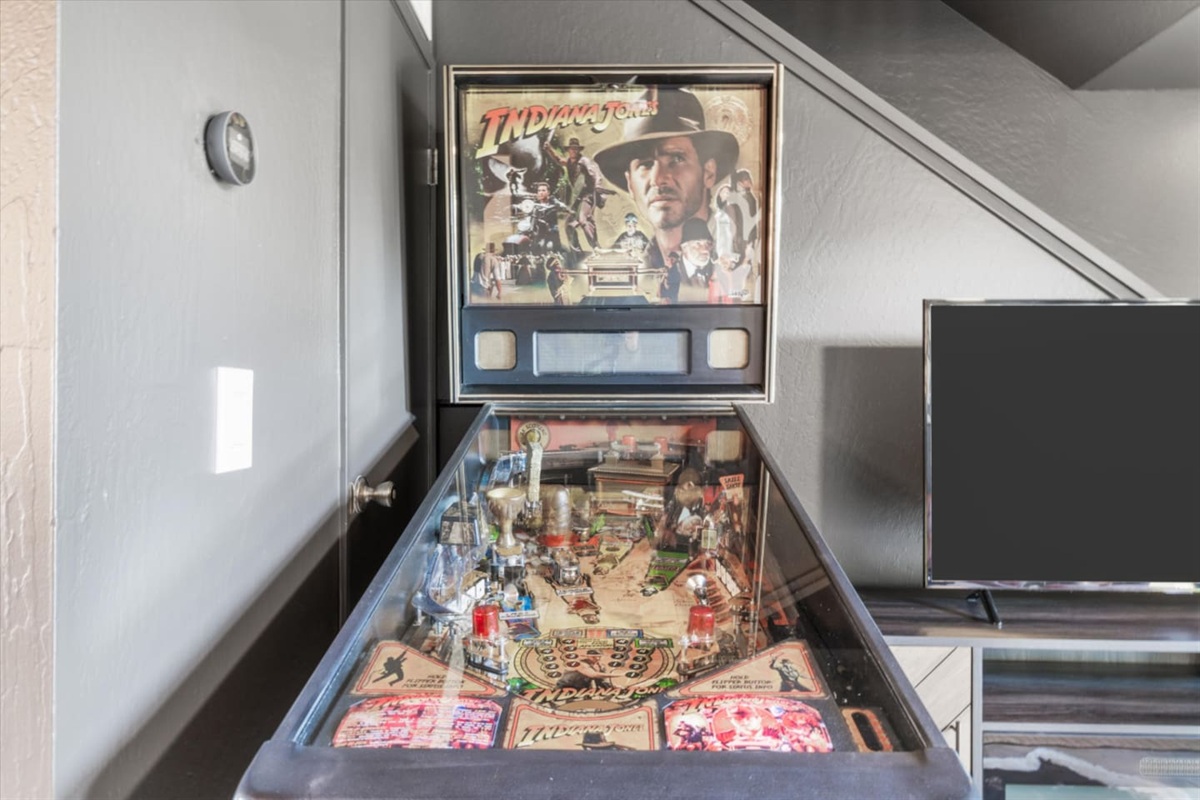 Indiana Jones pinball machine next to the TV for a fun little game-night bonus.