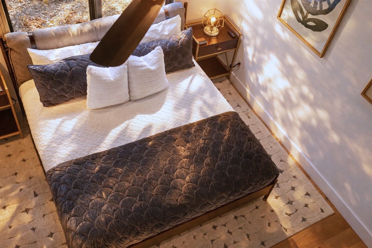 Sink into soft layers, warm lighting, and peaceful forest views in this cozy bedroom designed for deep rest and slow mornings.