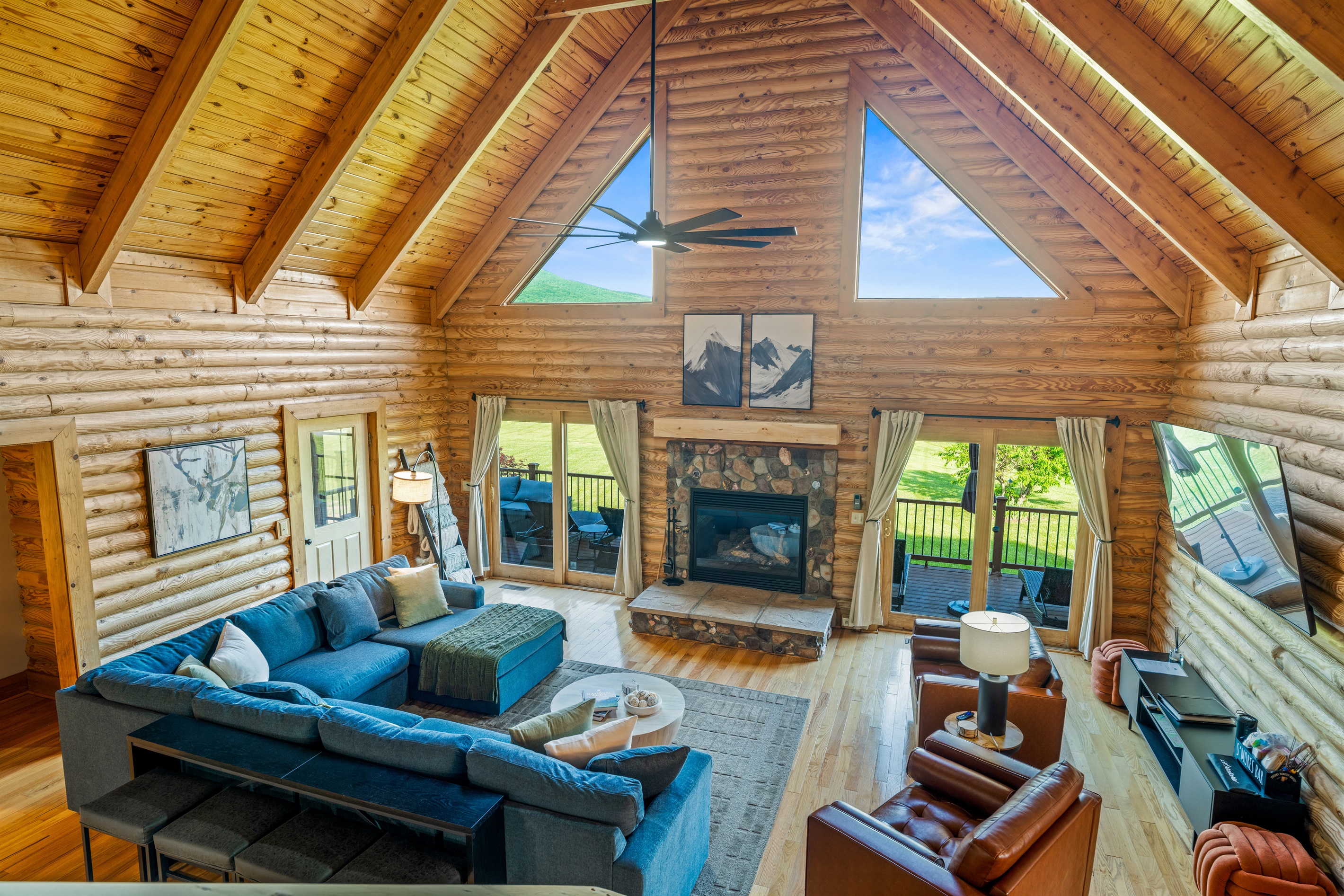 Wide-open living space with vaulted ceilings, deep blue sectionals, and unobstructed Shenandoah views. Plenty of room for the whole crew to spread out and unwind.