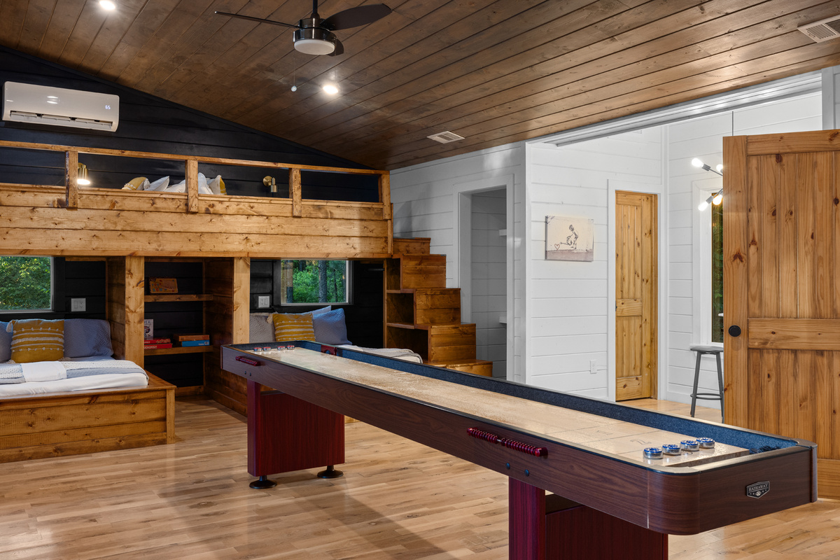 A lively bunk room entertainment corner featuring over 100 arcade-style games, creating the perfect hangout spot for friendly competition, laughter, and unforgettable group moments after a day of adventure. 🎮