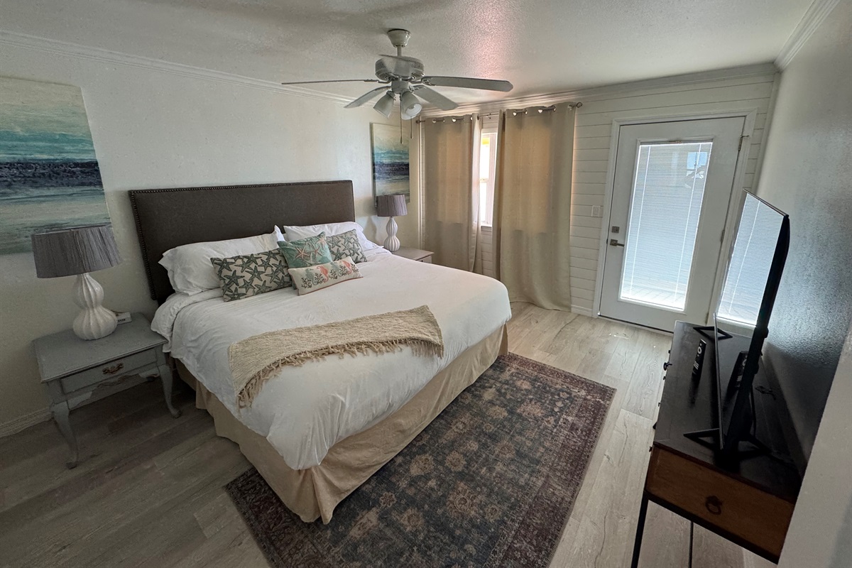 Master bedroom with king bed and smart tv plus access to balcony with oceanview