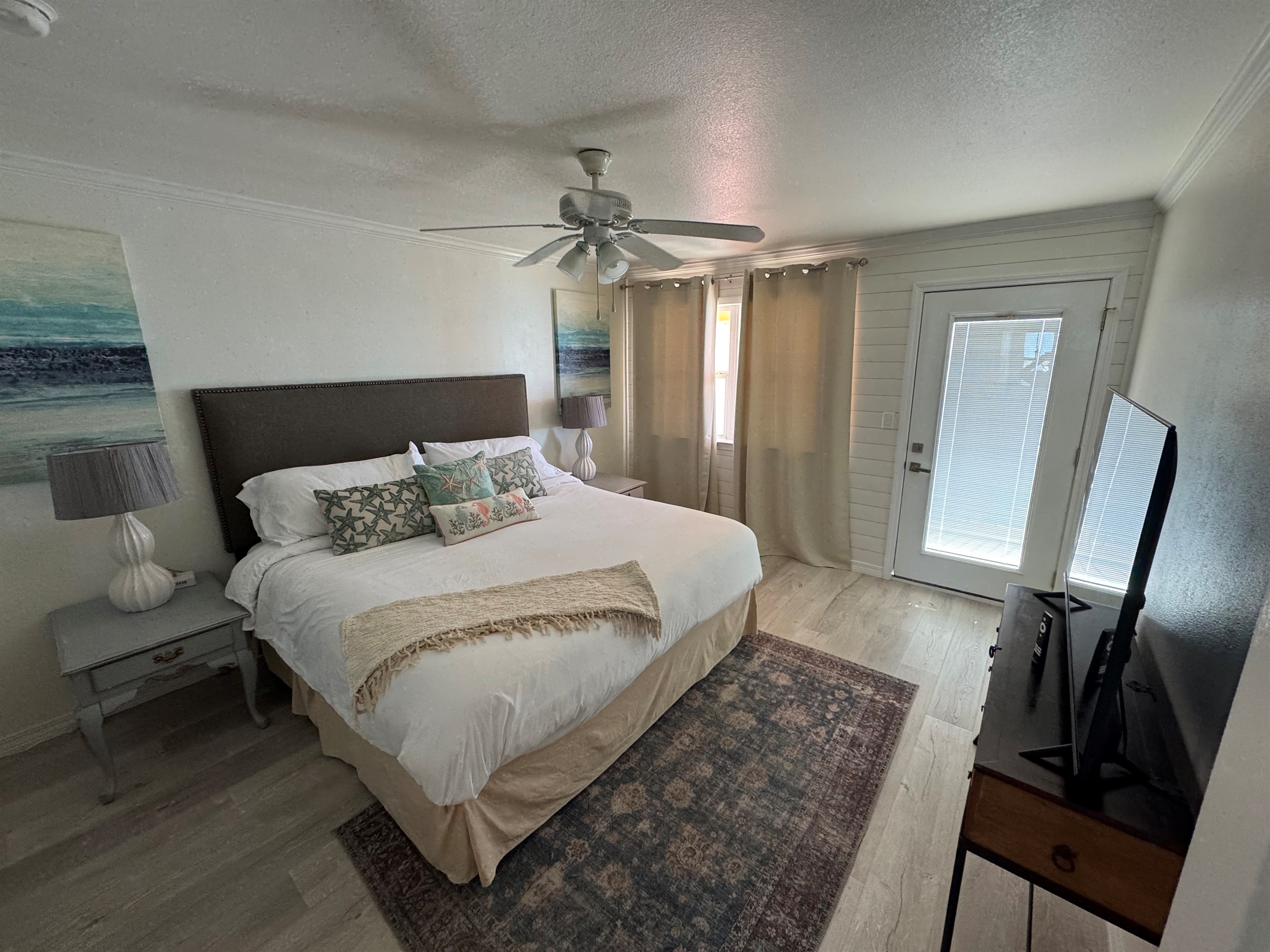 Master bedroom with king bed and smart tv plus access to balcony with oceanview