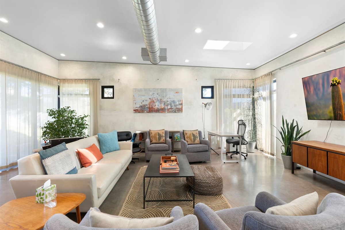 Bright and airy living room with cozy seating, a workspace nook, and stylish modern decor.