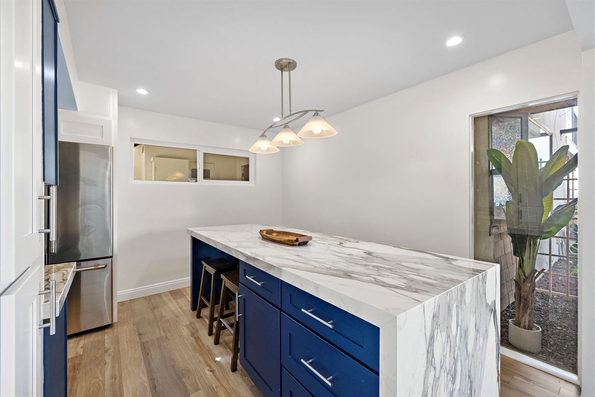 Bright dining area featuring seating for six around a stunning marble kitchen island