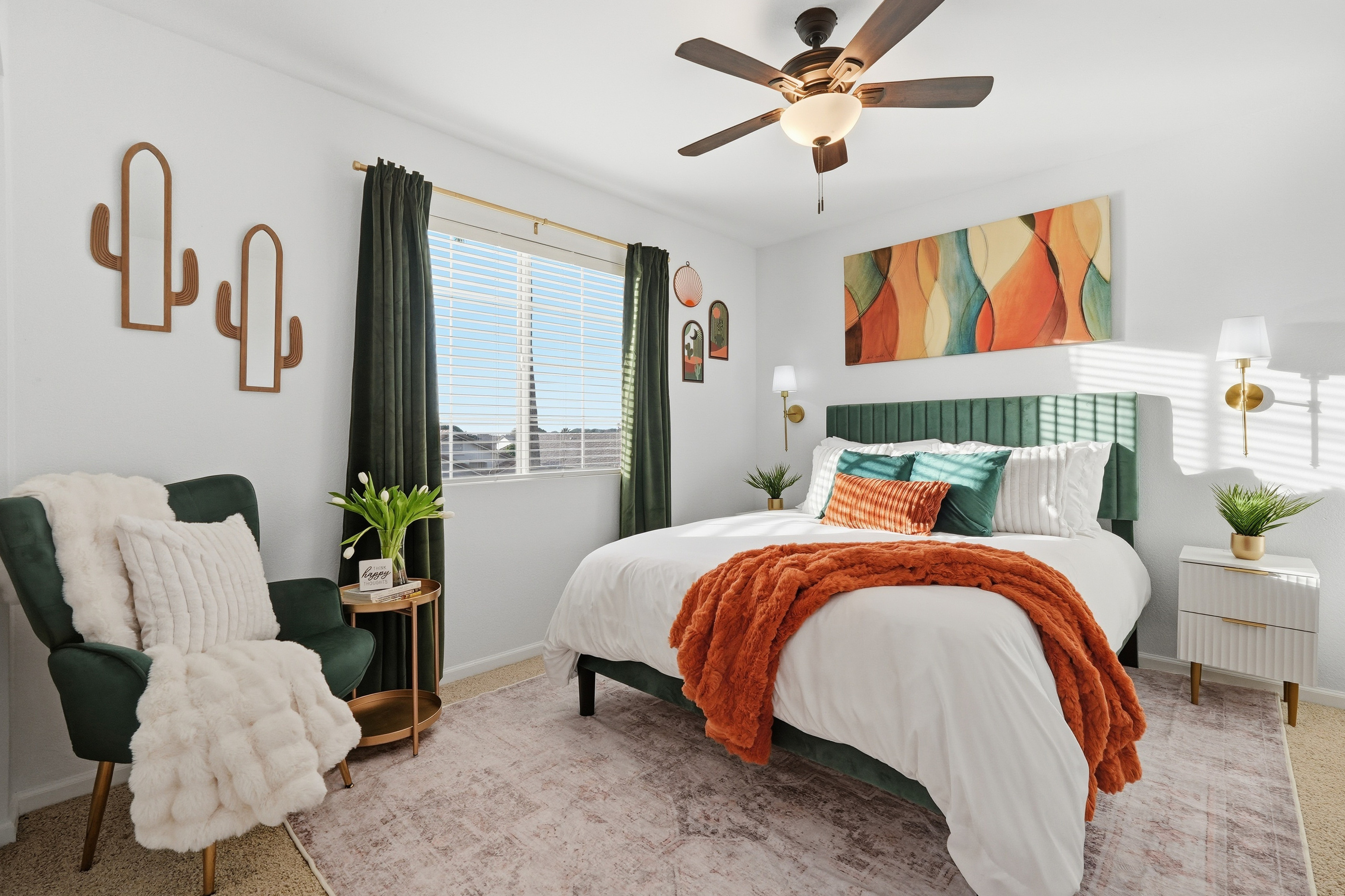 Bedroom with queen bed, accent chair, ceiling fan, and warm desert-inspired styling for a comfortable stay.