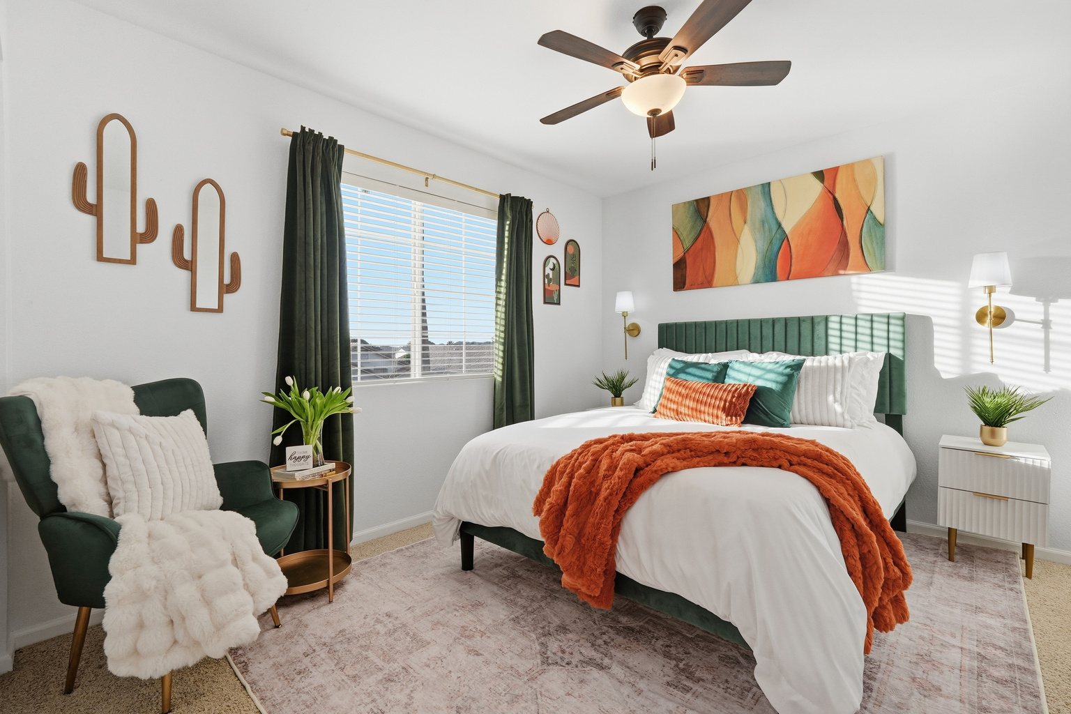 Bedroom with queen bed, accent chair, ceiling fan, and warm desert-inspired styling for a comfortable stay.