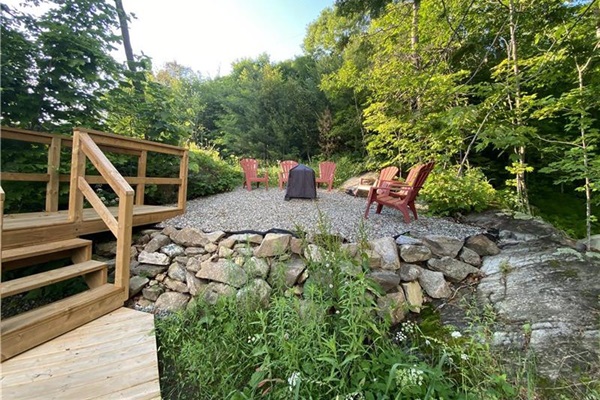 Firepit area behind cottage on hill.