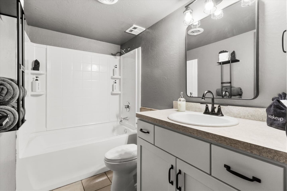 Full bathroom with a shower/tub combo, vanity storage, and fresh towels ready for guests.