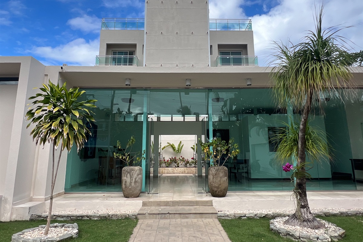 Modern glass entrance with tropical landscaping