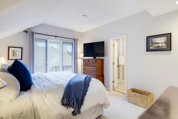 The spacious primary bedroom features a king bed, Smart TV, vaulted ceiling, and private en-suite bath.