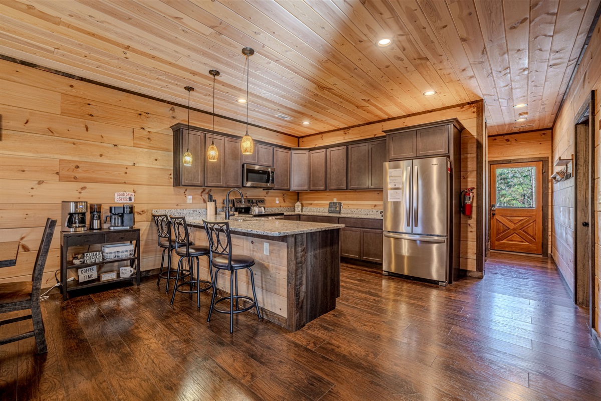 Fully equipped chef’s kitchen with stone countertops and stainless appliances.