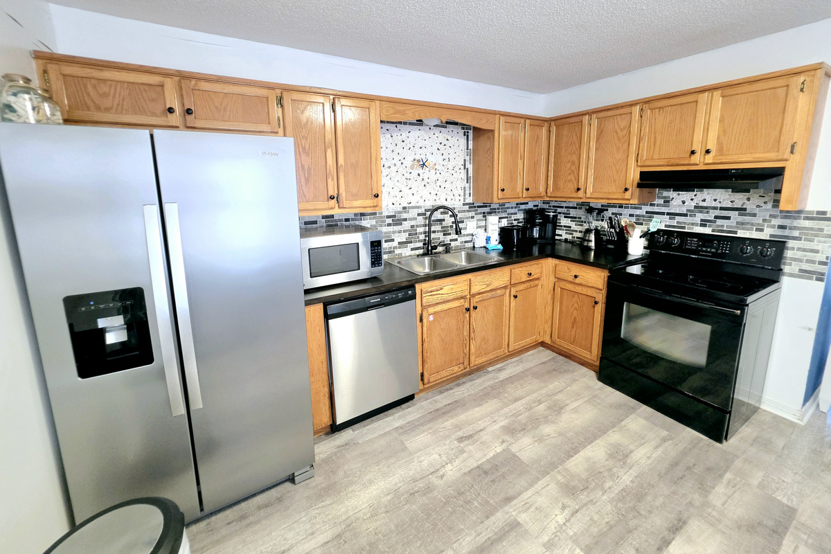 Kitchen with stainless refrigerator, dishwasher and microwave