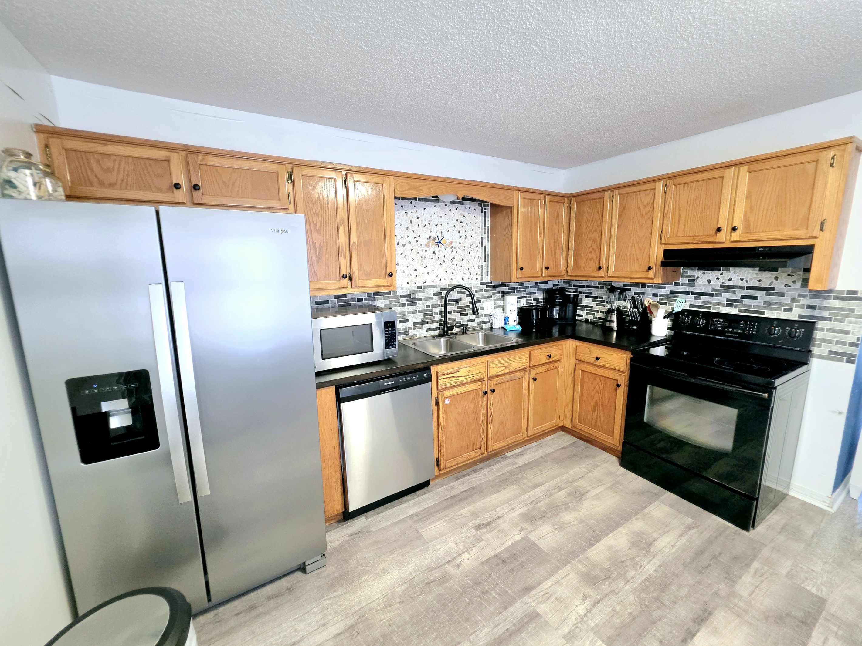 Kitchen with stainless refrigerator, dishwasher and microwave