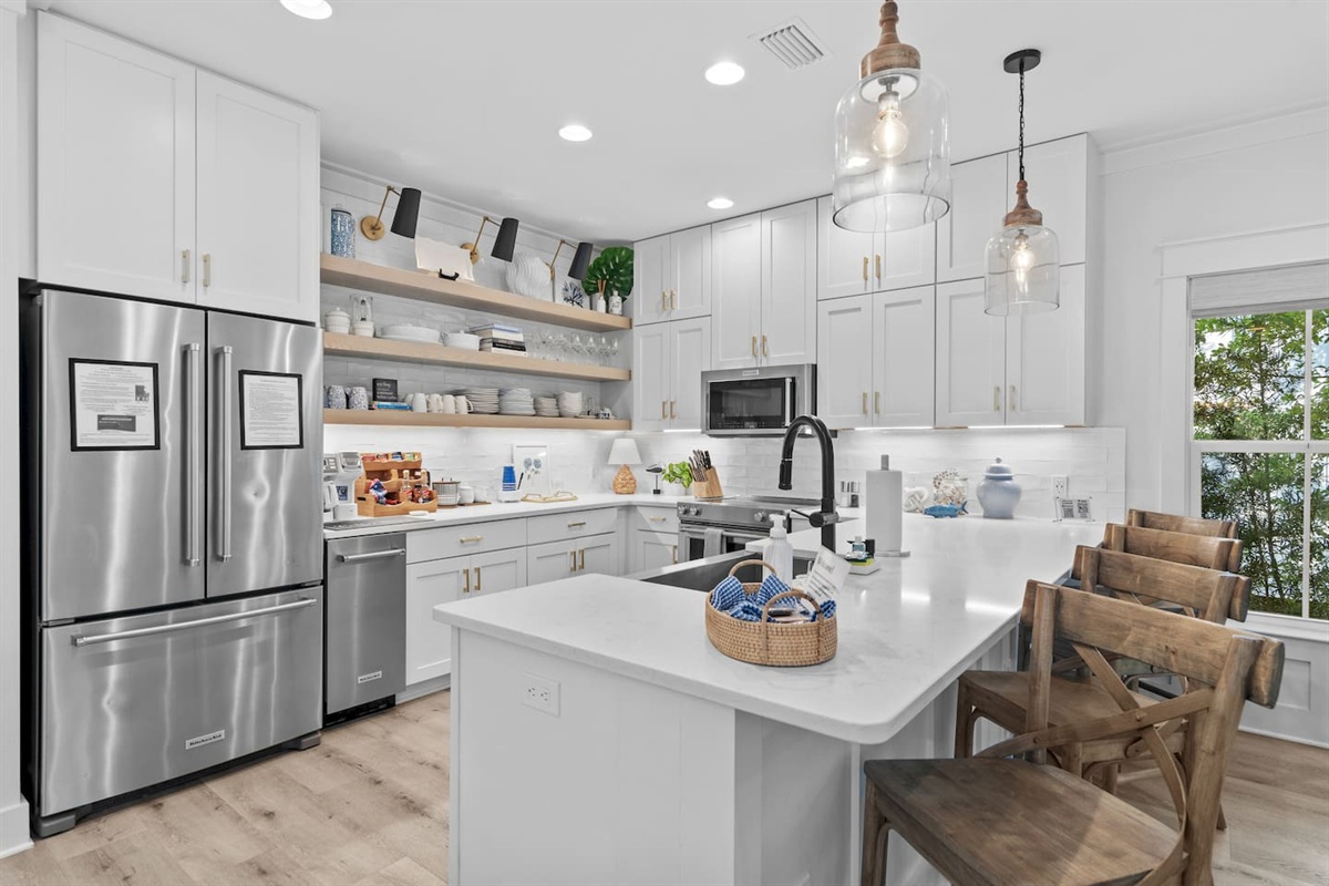 Fully stocked kitchen with KitchenAid refrigerator with filtered water and ice, a separate ice maker, stove, oven, microwave, and coffee/tea bar.