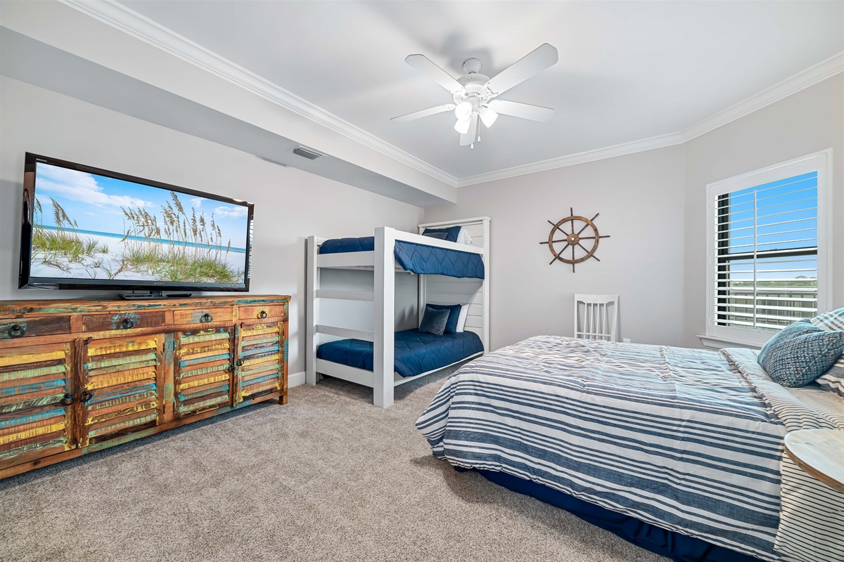 Perfect for families or groups, this guest room features a queen bed and a bunk bed providing a fun and functional space. The thoughtful design ensures comfort and convenience for all.