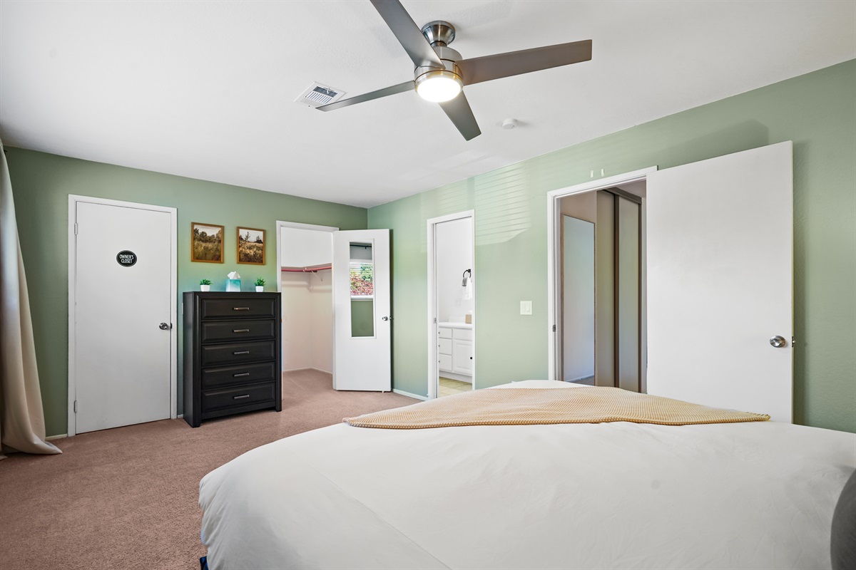 Retreat to the spacious primary bedroom featuring a plush king bed and a calm, relaxing atmosphere.