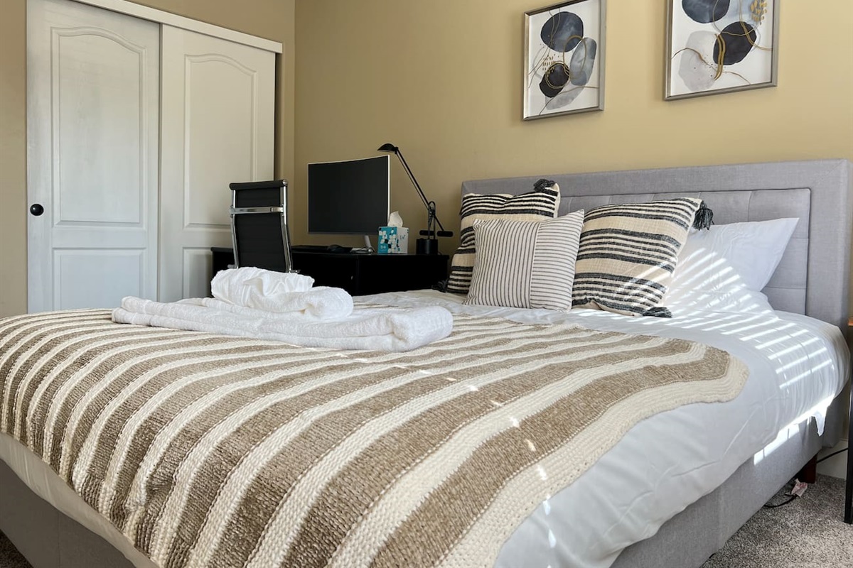 This bedroom has a queen bed and an office set up. 