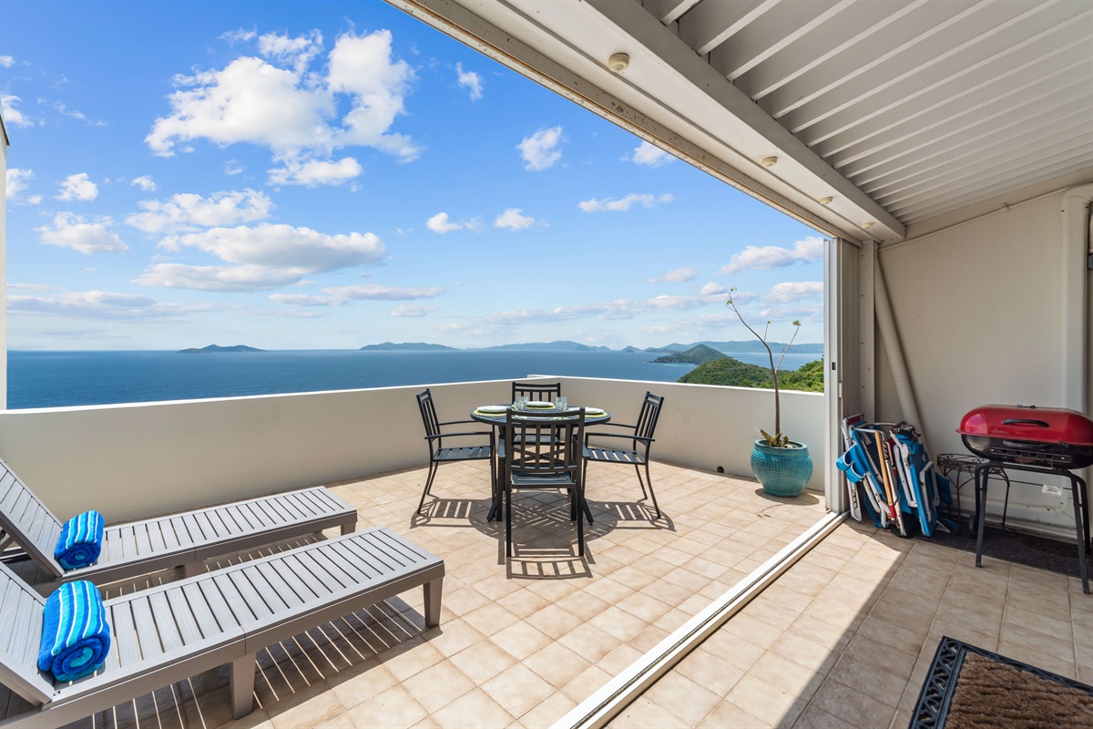 Outdoor dining and sun loungers with 180 degree views of the islands.