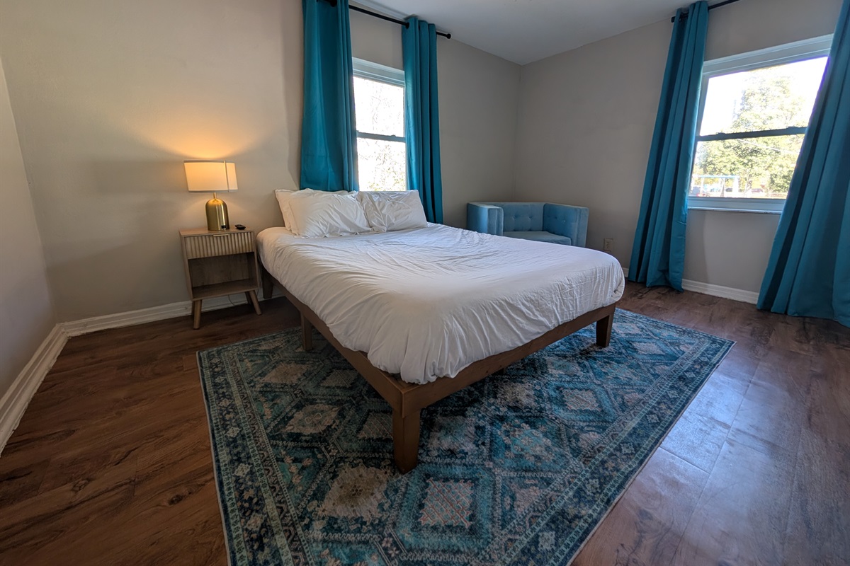 Master bedroom with queen bed, smart TV and chair