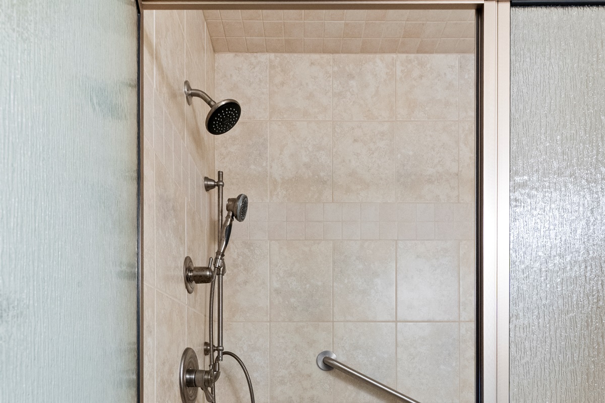 Sleek Shower Retreat: Refresh in a spacious, modern shower with dual showerheads and elegant tiles!