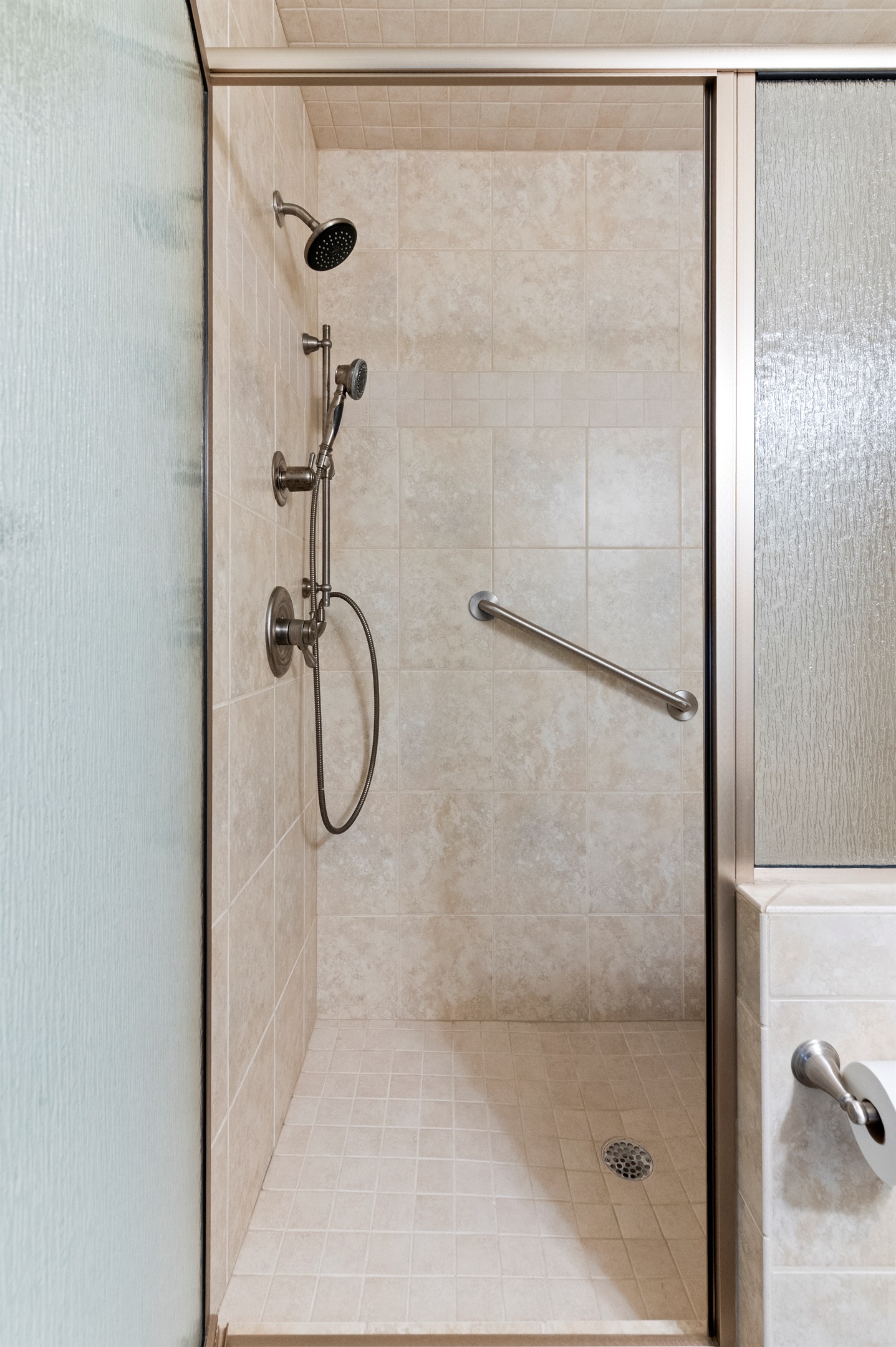 Sleek Shower Retreat: Refresh in a spacious, modern shower with dual showerheads and elegant tiles!
