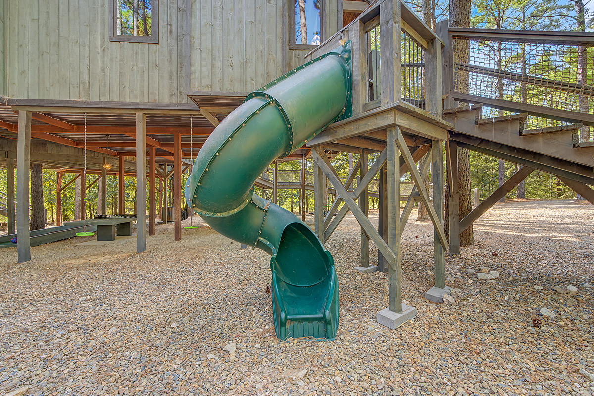 From the upper deck straight down to the play area — because every great treehouse needs a slide.