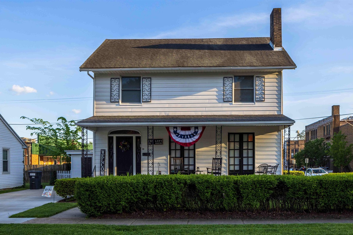 The front of the house is lined with hedges. 