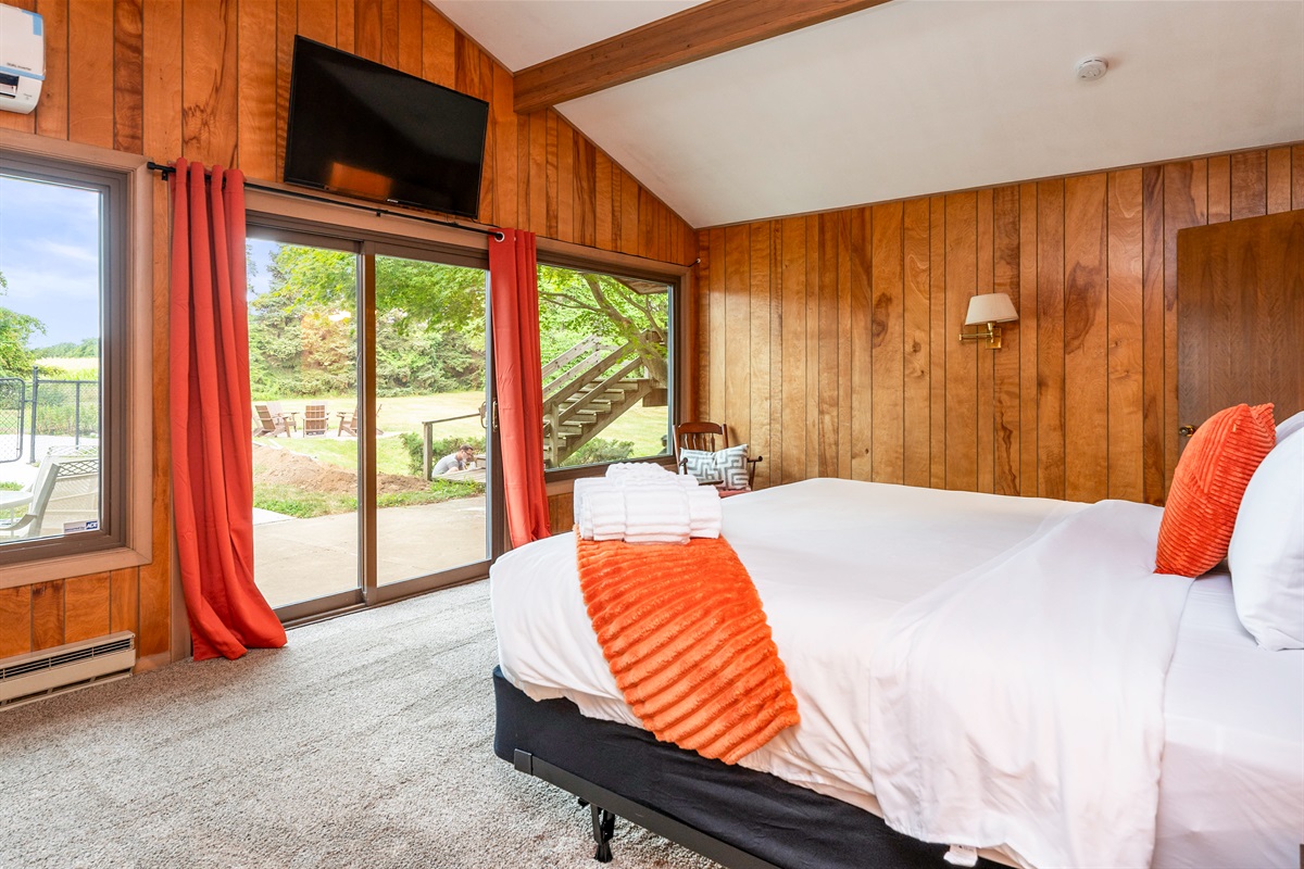 Spacious bedroom with a king bed, vaulted ceiling, and direct patio access for fresh air and poolside relaxation.