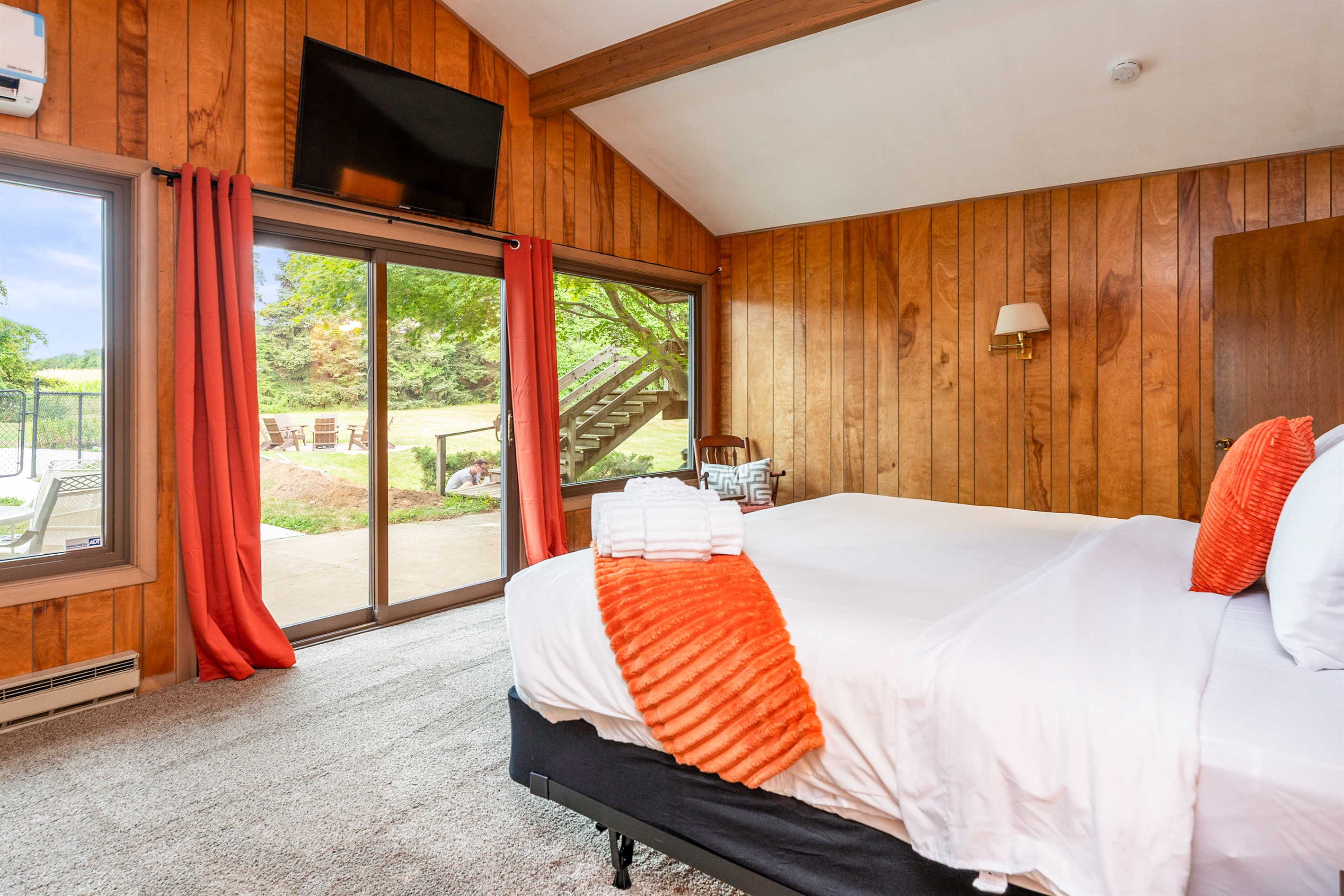 Spacious bedroom with a king bed, vaulted ceiling, and direct patio access for fresh air and poolside relaxation.
