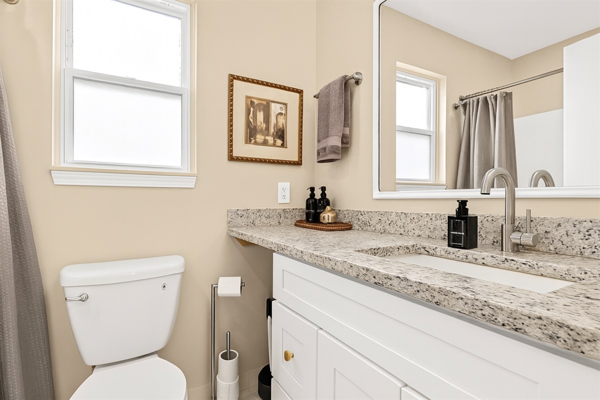 n our bathroom, you'll find a straightforward yet highly functional arrangement, complete with a user-friendly vanity for your convenience.