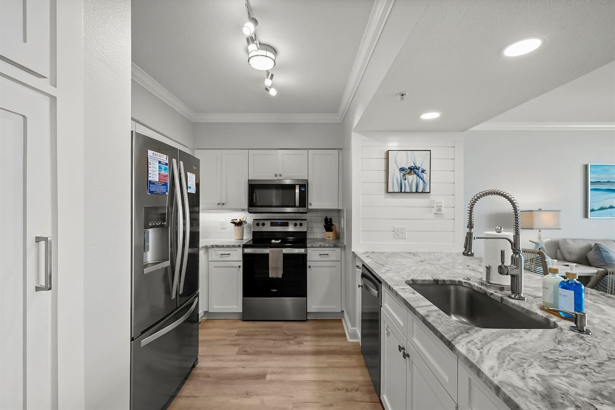 Whip up meals in this fully equipped kitchen featuring stainless steel appliances, beautiful countertops, and coastal charm—perfect for enjoying beachside breakfasts or sunset dinners at your Panama City Beach getaway.