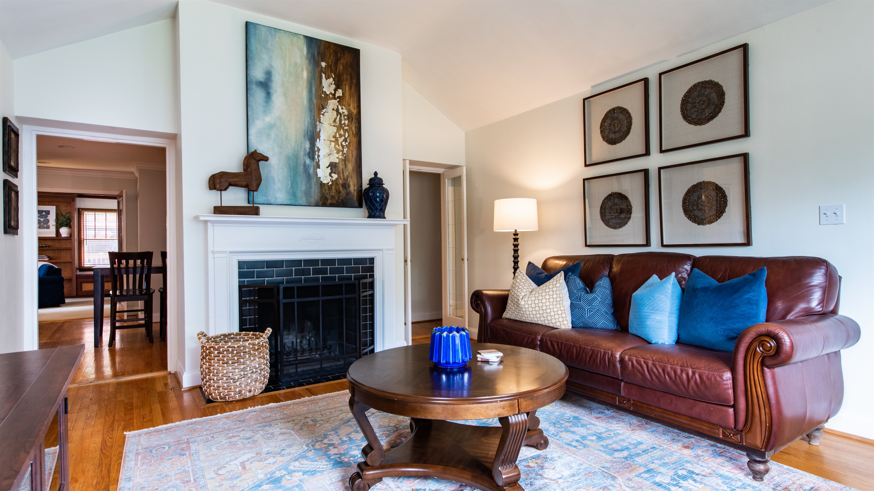 Cozy up by the fireplace in this elegant living room after the Bourbon Trail! Features a leather sofa, wooden coffee table, and stylish decor—ideal for a relaxing evening with a glass of bourbon.