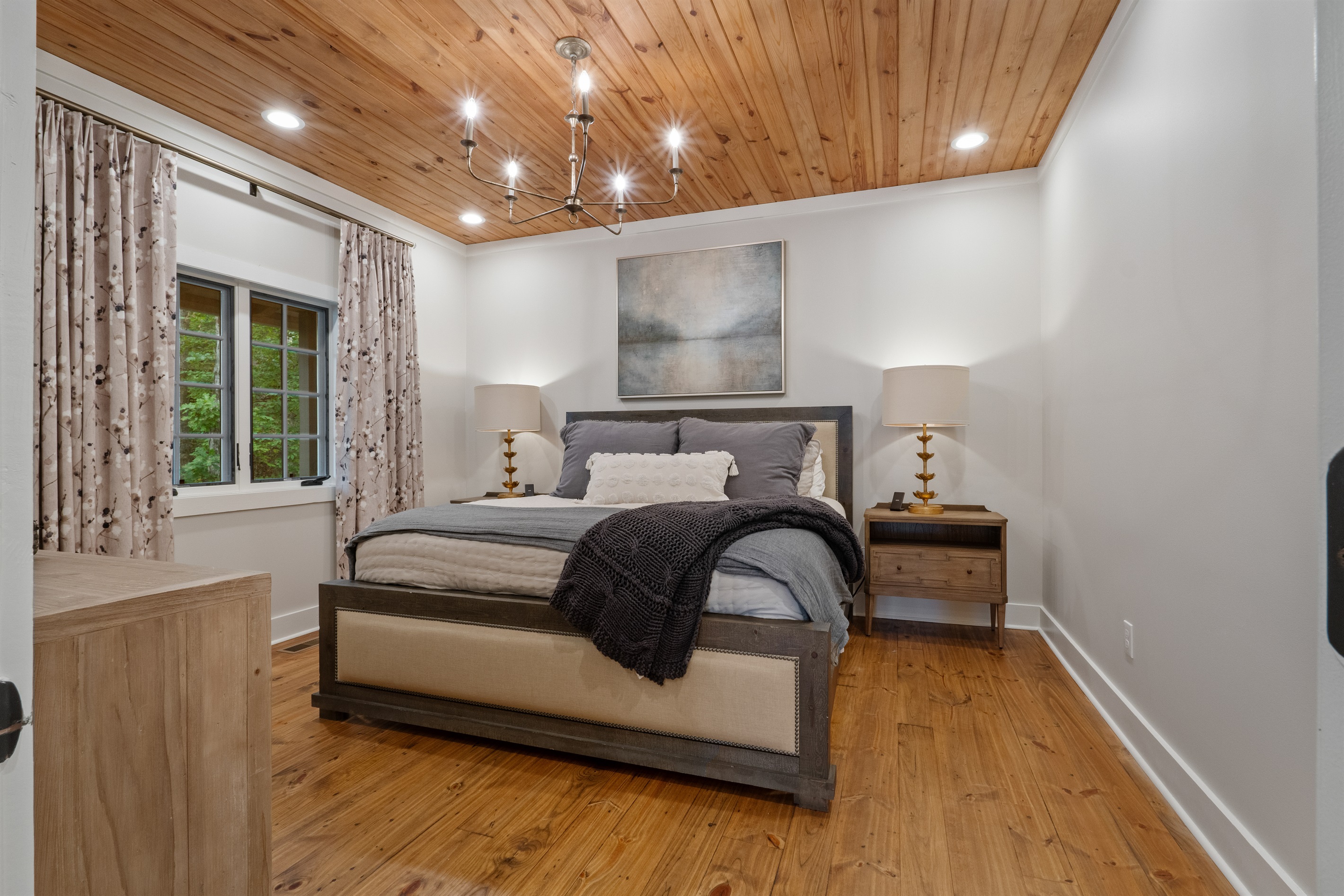 The master bedroom on the main floor features a king bed and a private en suite bathroom, offering comfort and convenience in a relaxing lakefront setting.
