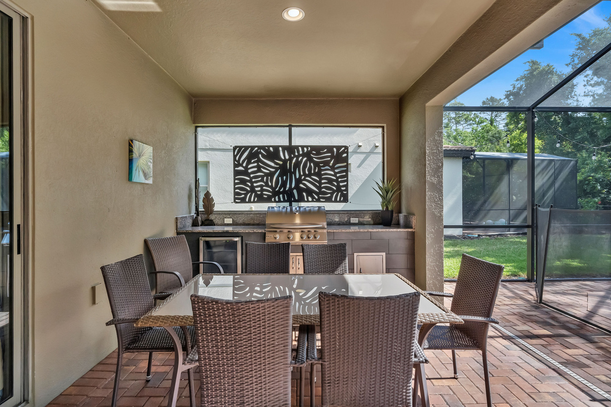 Patio with grill, mini fridge, and table with chairs
