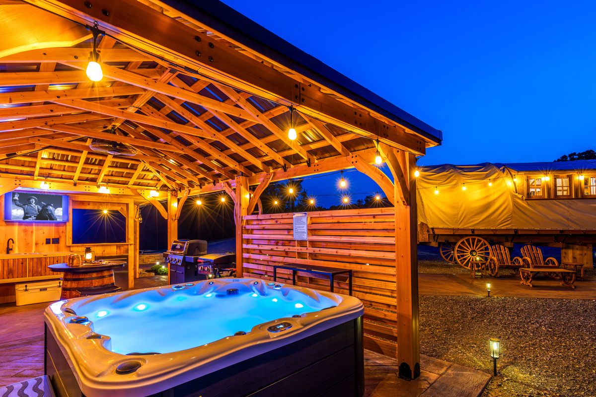 Your private covered spa pavilion with hot tub, outdoor TV, string lights, and western charm.