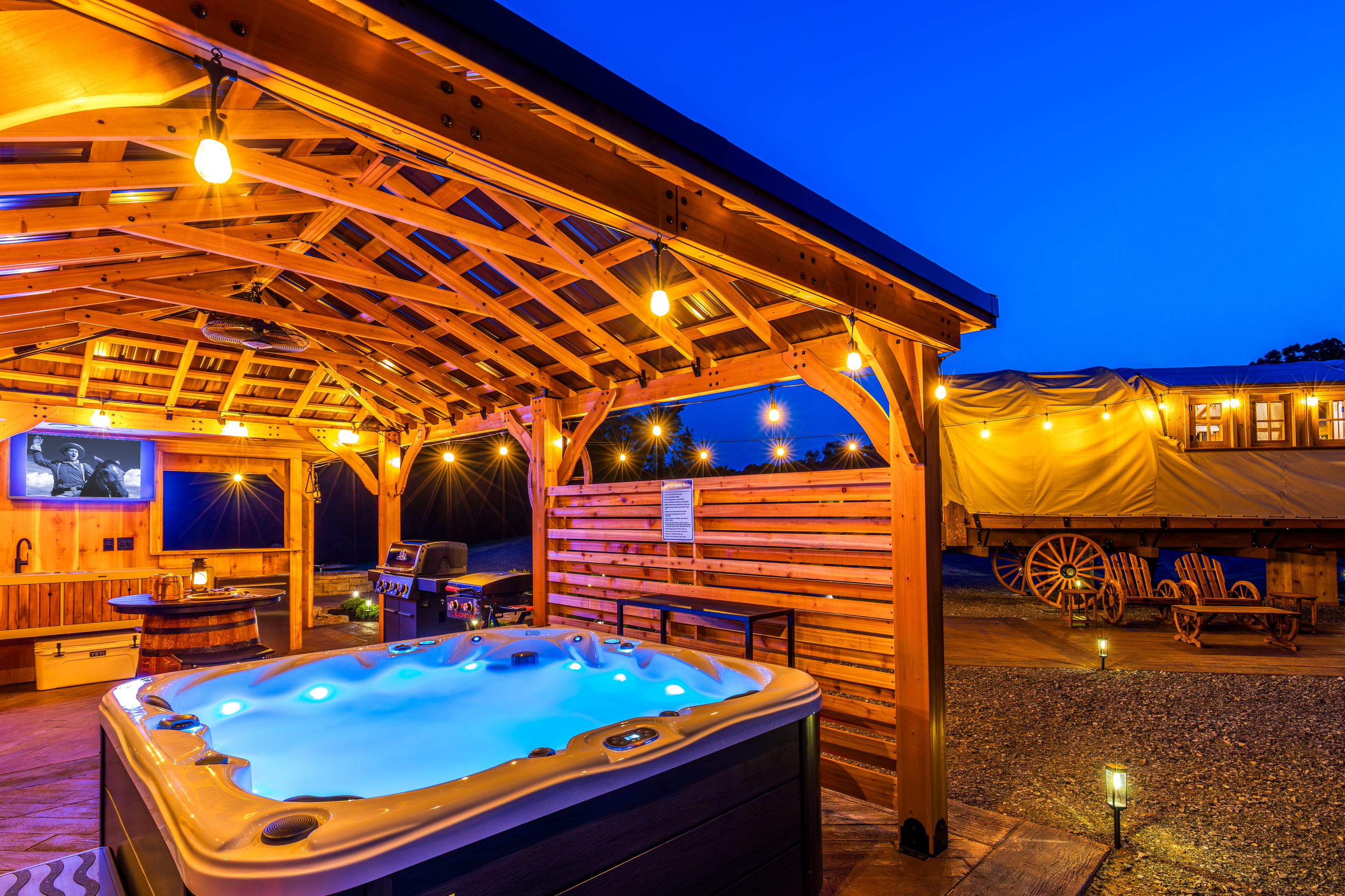 Your private covered spa pavilion with hot tub, outdoor TV, string lights, and western charm.