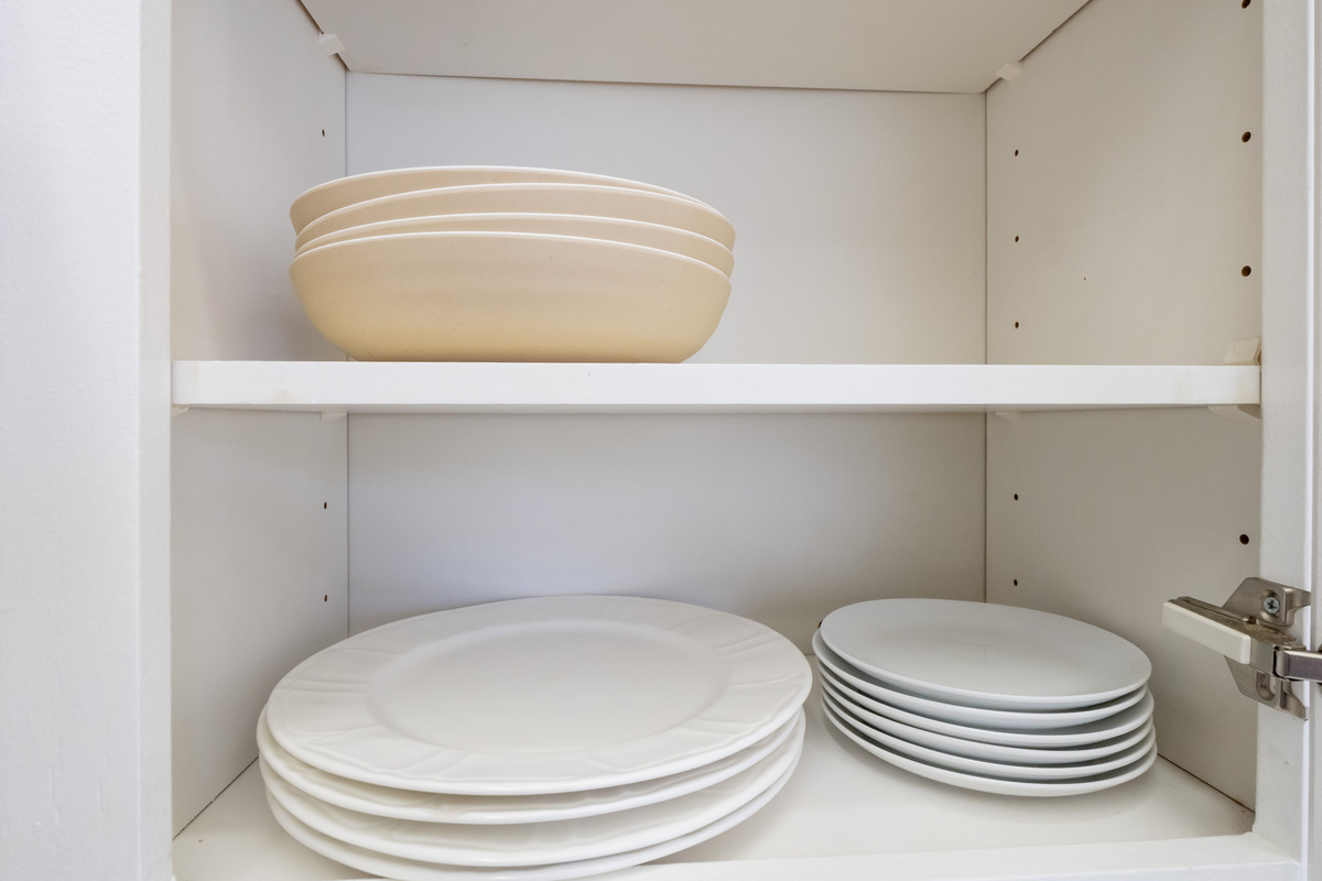 The kitchen is fully stocked with plates, bowls, and everyday dining essentials, making it easy to enjoy meals together during your stay.
