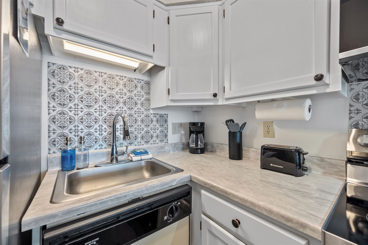 Thoughtfully stocked prep space with clean finishes, tile backsplash, and everyday kitchen essentials close at hand