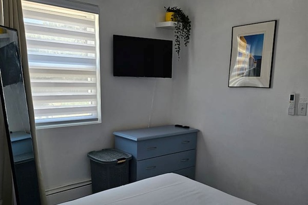 Flat screen App TV and chest of drawers for storage, room darkening curtains