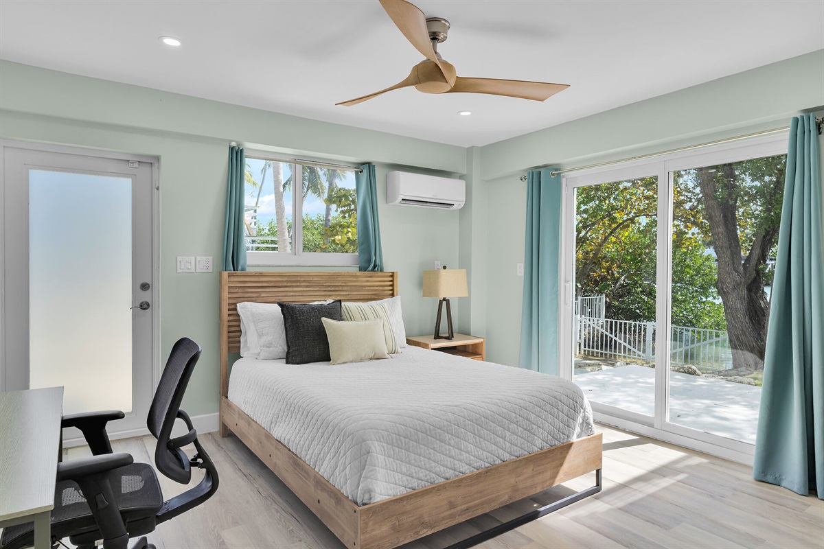 Downstairs guest bedroom with queen bed, desk and chair. 