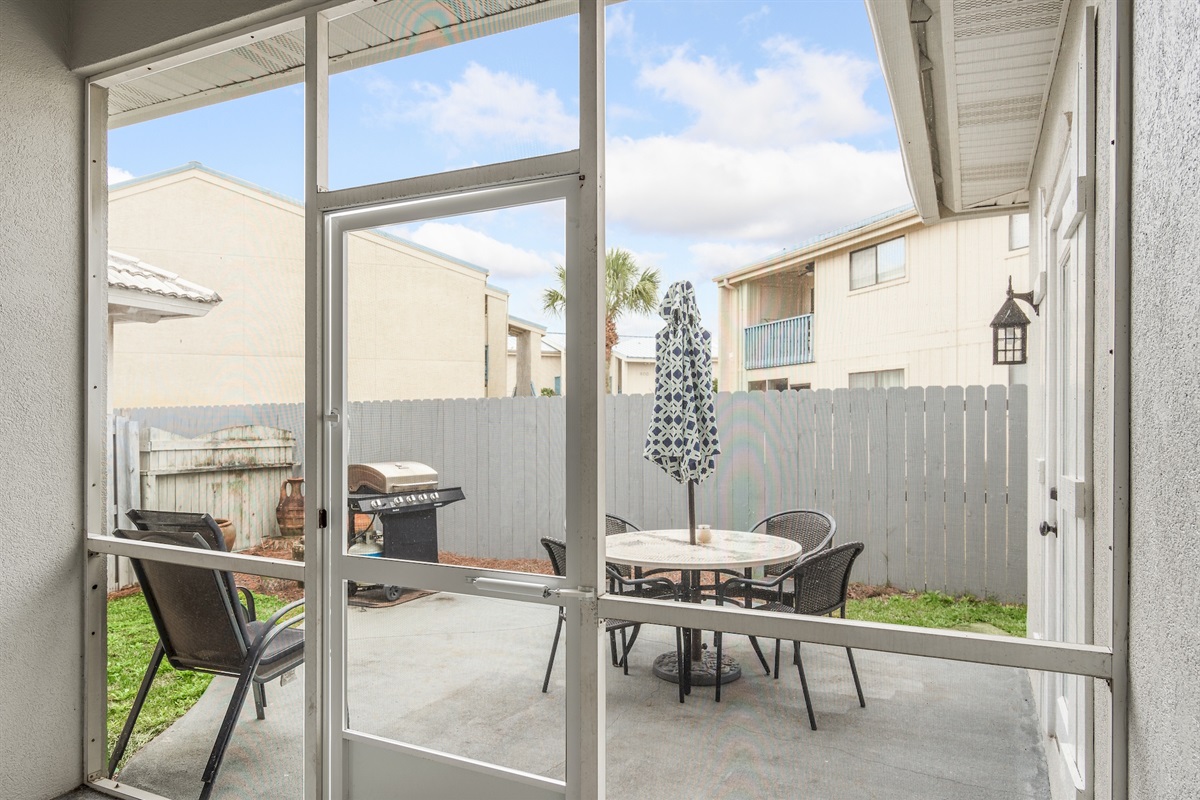Screened patio with outdoor dining and fenced backyard