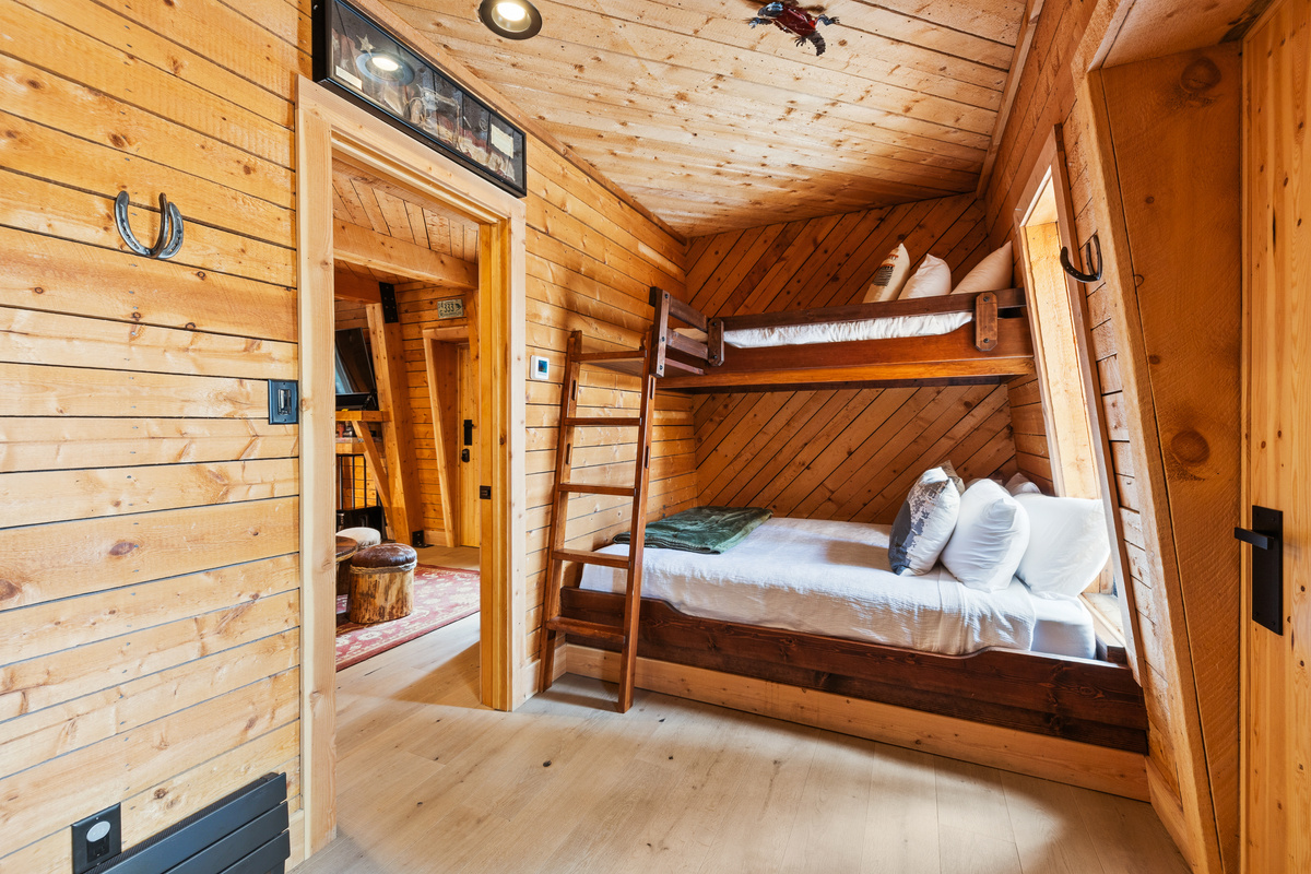 Twin-over-Queen bunk room with twin sleeper. This room can sleep up to four. Pocket door closes room off from loft seen in left. Twin sleeper in foreground (not seen in this photo). Door on right is walk-in closet. 