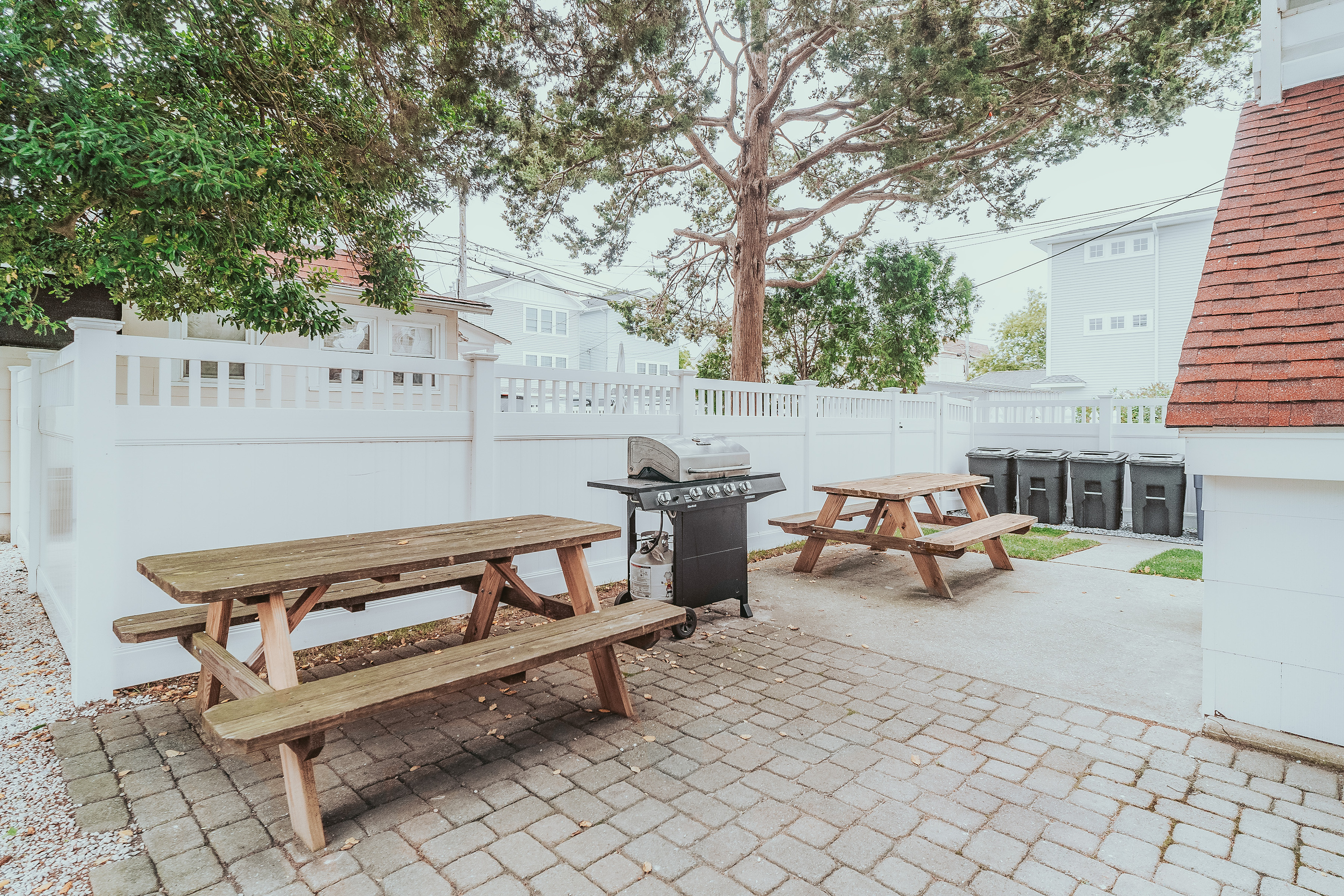 Paver Patio Area Showing Picnic Tables, Outdoor BBQ Grill, and Trash Storage Station