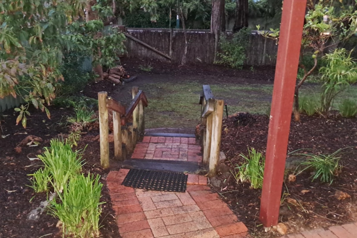 Stairs leading from the BBQ area to the large lawn area for the kids, and a shed for the bikes!