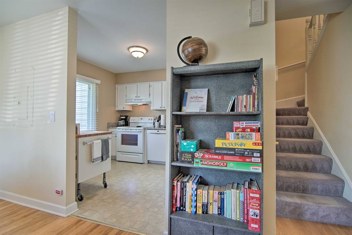 The kitchen, books, games and the staircase to the second and third bedrooms, workstation, and second bath are shown.