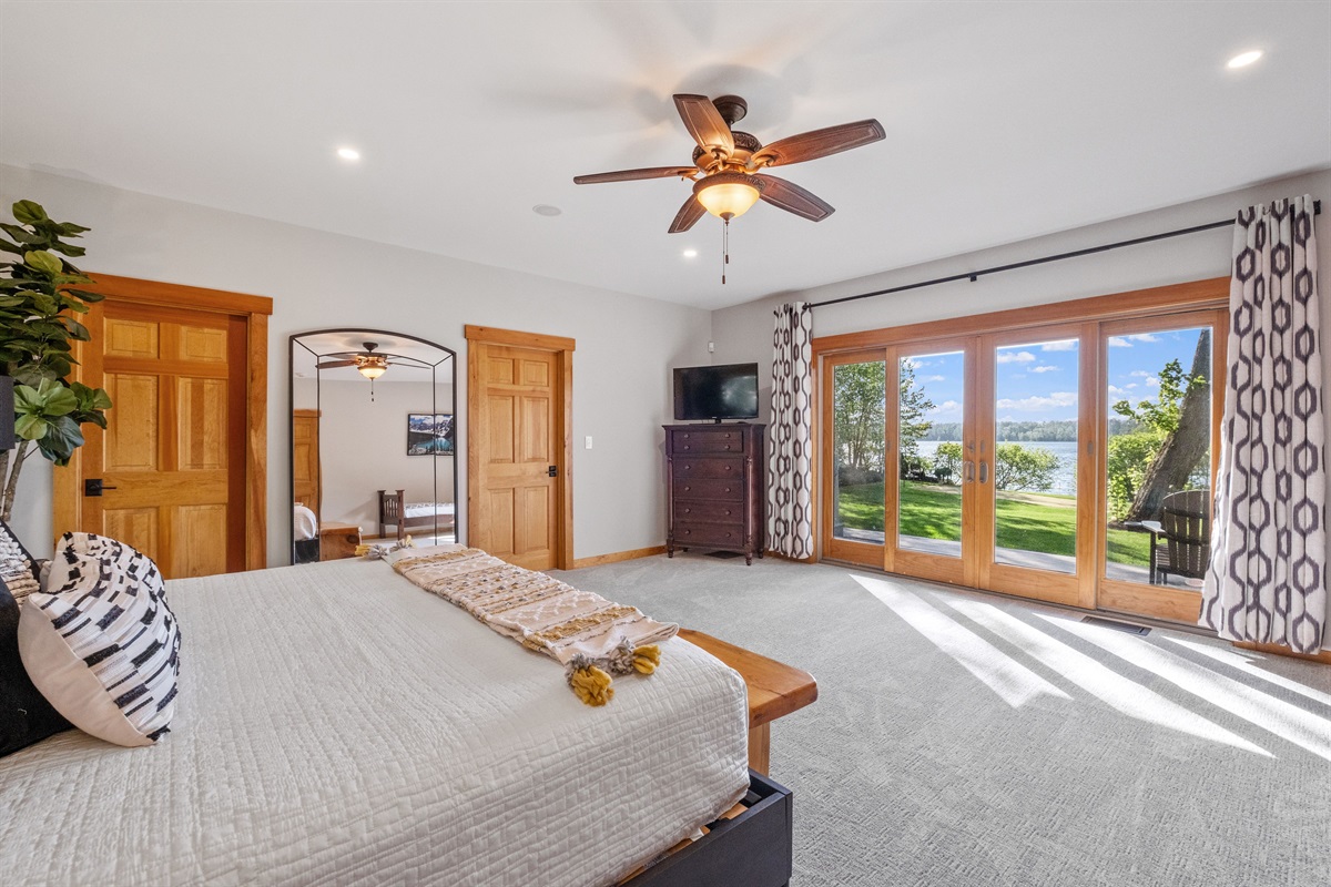 First floor master bedroom ensuite with king and twin beds overlooking Lake Winnipesaukee with hot tub on outside deck.