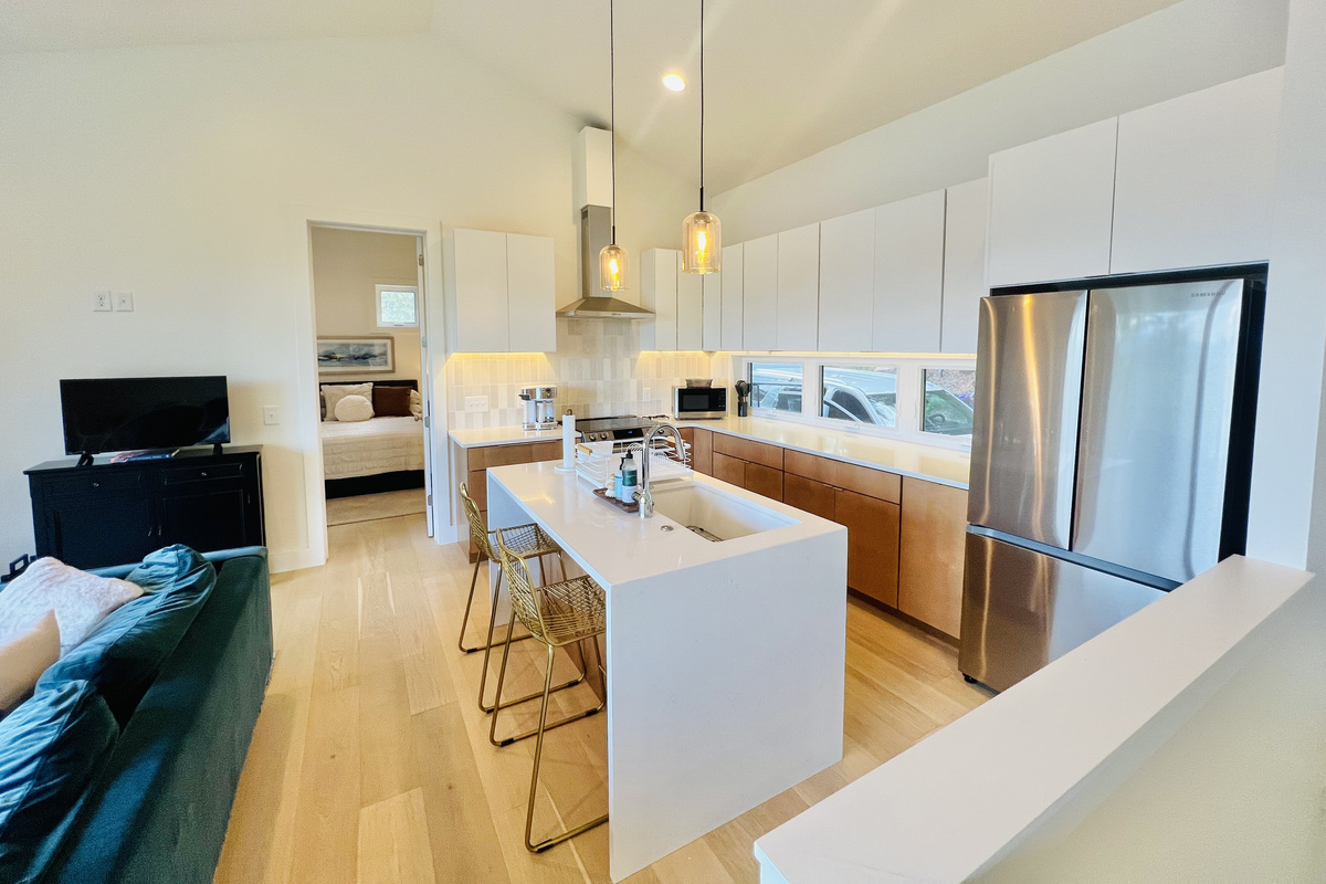 Cook, gather, and connect. This fully equipped kitchen features stainless steel appliances, modern finishes, a spacious island with seating, and plenty of room to prepare meals while staying connected to the rest of the group.