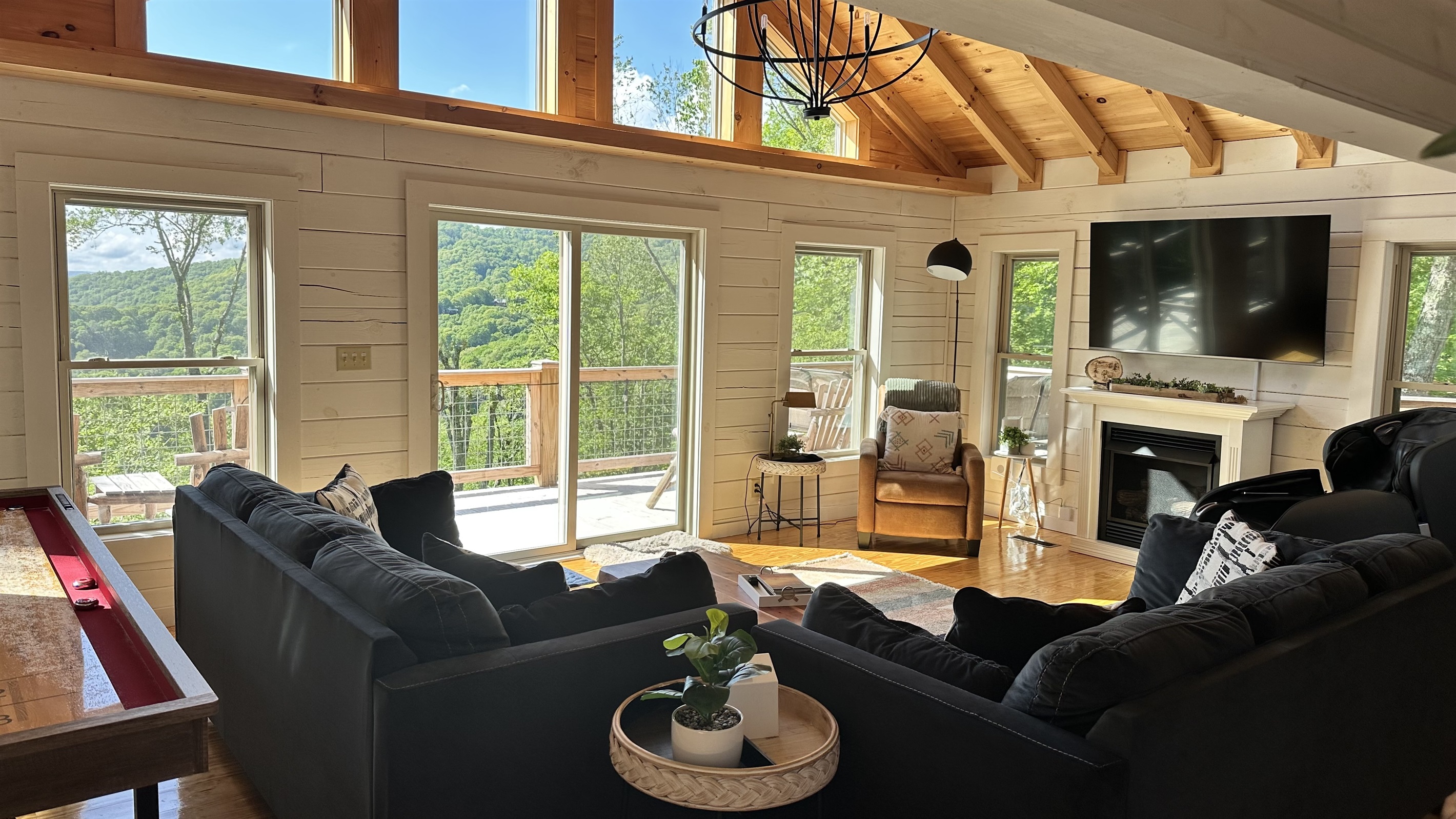 Bright family room with amazing mountain views, fireplace, Shuffleboard Table, and massage chair!  Two large couches that will seat your whole group!